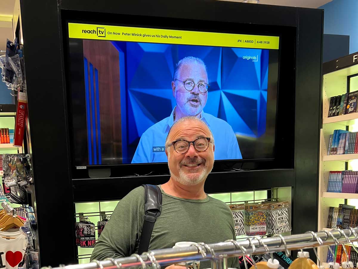 Peter Winick in a shop and also on the TV behind him.
